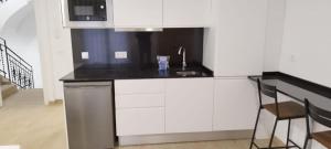 een witte keuken met een wastafel en een magnetron bij SM Apartments in Lleida