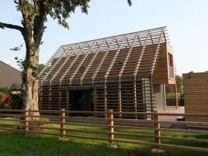 un edificio con una valla de madera frente a un árbol en Chalet Wendorf, en Wendorf