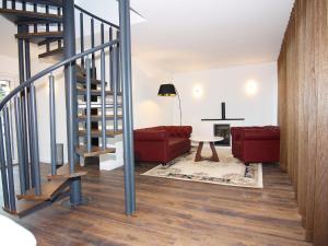 sala de estar con escalera y sofá rojo en Chalet Wendorf, en Wendorf