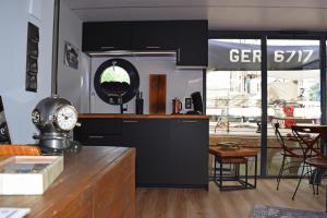 a kitchen with black cabinets and a clock on a counter at Houseboat Leni Flensburg in Flensburg