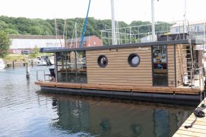 Houseboat Leni Flensburg في فلنسبورغ: قارب خشبي كبير مرسى في الماء