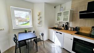 une petite cuisine avec une table et une fenêtre dans l'établissement Ferienwohnungen Krüger 'Apartment Marina', à Gammelsbach