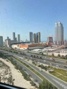 a highway in a city with buildings and traffic at Cozy Lovely Apartment in Manama