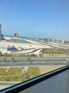 a view of a city with a beach and a highway at Cozy Lovely Apartment in Manama