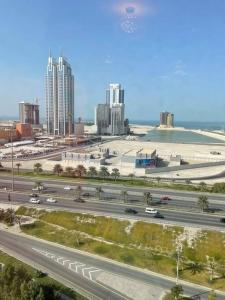 a highway in front of a city with tall buildings at Cozy Lovely Apartment in Manama