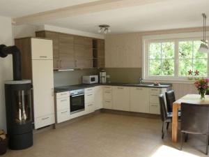 a kitchen with white cabinets and a table and a window at Holiday home waterfall in Wasserfall