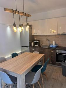 a kitchen with a wooden table and blue chairs at Merchia Bay Villas Mykonos in Merchia Beach