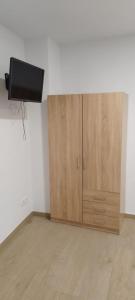Habitación con 2 armarios de madera y TV en la pared. en SM Apartments en Lleida