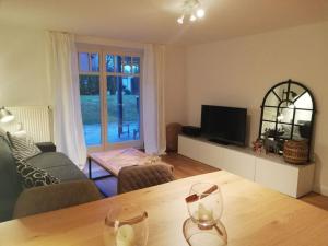 uma sala de estar com uma mesa e uma televisão em Holiday apartment seahorse em Timmendorfer Strand