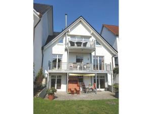 uma casa branca com uma varanda e um pátio em Holiday apartment seahorse em Timmendorfer Strand