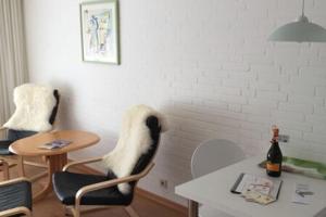 Apartment in Westerland في فيسترلاند: غرفة معيشة مع طاولة وكرسي وطاولة