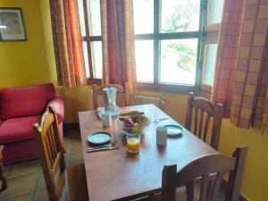 una mesa de madera con un bol de fruta. en Alojamientos El Castillo, en El Berrueco