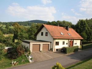 uma casa branca com um telhado vermelho e uma entrada em Holiday apartment Weipert em Ehrenberg