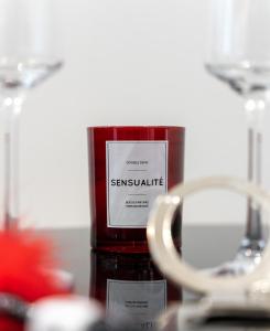 a red candle sitting on a table next to a pair of glasses at Secret Room Spa Agde in Agde +11 photos