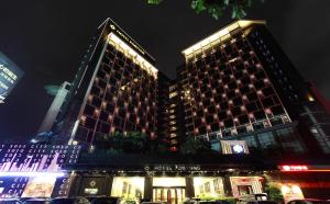 two tall buildings with lights on them at night at Hotel Fortune in Shunde