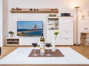 uma sala de estar com dois copos de vinho e uma televisão em High Geest 4 - including many extras em Sahlenburg