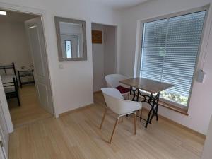 ein Esszimmer mit einem Tisch, Stühlen und einem Fenster in der Unterkunft Holiday home Werder Havel in Werder