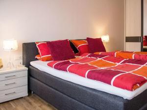 オーバーキルヒにあるFantastic apartment in Oberkirchのベッドルーム1室(大型ベッド1台、赤とオレンジの枕付)