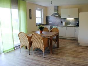 une cuisine avec une table en bois et des chaises ainsi qu'une cuisine avec des placards blancs dans l'établissement Fantastic apartment in Oberkirch, à Oberkirch