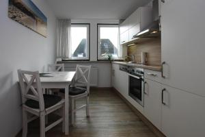 a kitchen with a table and chairs in a room at Apartment Tating in Tating