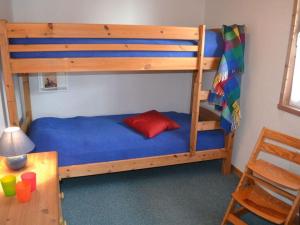 a bunk bed with a red pillow on a blue bed at Holiday home Vogelsang in Userin