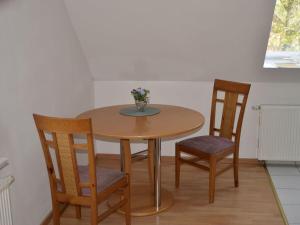 uma mesa de madeira com duas cadeiras e um vaso com flores em Holiday apartment nature view em Conow