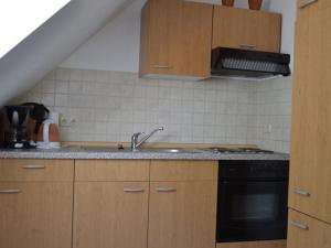 uma cozinha com armários de madeira, um lavatório e um fogão em Holiday apartment nature view em Conow