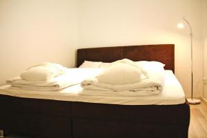 a bed with white blankets and pillows on it at Apartment house Der Krauterhof Drei Annen Hohne in Drei Annen Hohne