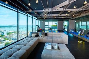 - un grand salon avec un grand canapé et de grandes fenêtres dans l'établissement Sea View 2 Bed Room Condo At Central Pattaya, à Pattaya