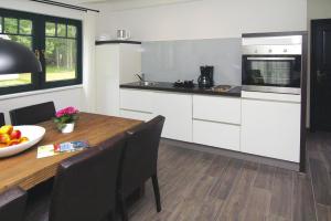 a kitchen with a wooden table and a dining room at Holiday home in Drewitz with a shared pool in Drewitz