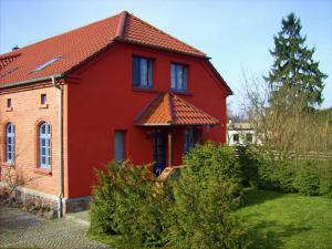 uma casa vermelha com um telhado vermelho em Holiday house by the lake em Fürstenwerder