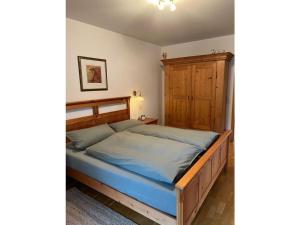 um quarto com uma cama grande e uma cabeceira em madeira em Holiday apartment Finkennest em Eisenbreche