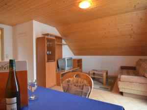 een woonkamer met een bank en een tafel met een wijnglas bij House full of charm with garden 10min from the Pointe du Raz in Cléden-Cap-Sizun