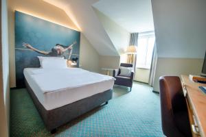 Erikson Hotel في شيندلفينجن: غرفة فندق فيها سرير و لوحة على الحائط