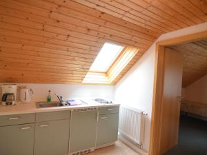 a kitchen with a sink and a skylight at House full of charm with garden 10min from the Pointe du Raz in Cléden-Cap-Sizun