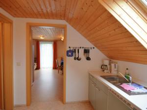 een keuken met een wastafel en een houten plafond bij House full of charm with garden 10min from the Pointe du Raz in Cléden-Cap-Sizun