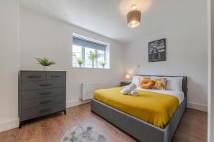 a bedroom with a bed and a dresser and a window at Luxury 2 Bedroom London Home - Vauxhall & Battersea in London