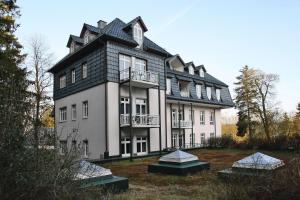 uma casa grande com um telhado de gambrel em Apartment in fir with a balcony or a terrace em Tanne