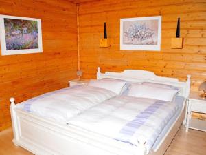 uma cama branca num quarto com paredes de madeira em Apartment near West Hamburg em Neubeuern