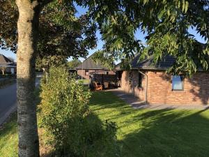 a brick house with a tree in the yard at North Sea holiday home Zinnäcker in Almdorf