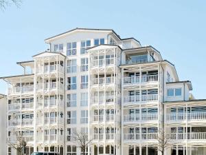 ein weißes Apartmenthaus mit weißen Balkonen in der Unterkunft 6 person holiday home in Gro enbrode in Großenbrode