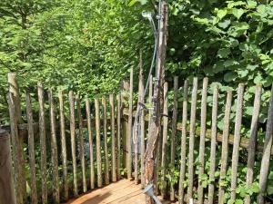 une clôture en bois avec un vélo attaché à celle-ci dans l'établissement Eco friendly chalet near the lake in Asten, à Tittmoning