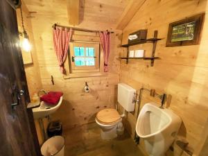 a wooden bathroom with a toilet and a sink at Eco friendly chalet near the lake in Asten in Tittmoning