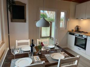 a kitchen with a table with plates and wine glasses at Holiday home The Beach Hut in Schönhagen