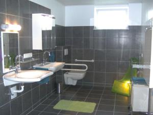 Apartment in Olsberg في Ehrenberg: حمام فيه مغسلتين ومرحاض ونافذة