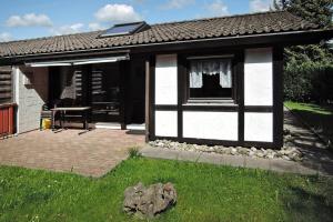 a small white and black house with a window at Tennenbronn Holiday Park Tennenbronn in Tennenbronn