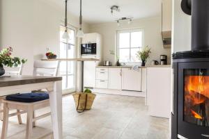 a kitchen with a fireplace and a table and a stove at Holiday house Fuhlendorf in Fuhlendorf