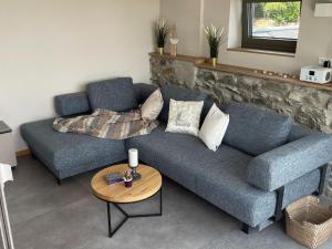 ein Wohnzimmer mit einem blauen Sofa und einem Tisch in der Unterkunft Well equipped apartment in Monschau near bus stop in Mützenich
