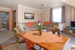 una sala de estar con una mesa con flores. en Apartment house Nicole Zinnowitz, en Zinnowitz