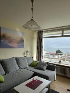 a living room with a couch and a table and a window at Strandhotel Wohnung 33 in Dahme